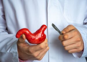 doctor holding stomach and scalpel