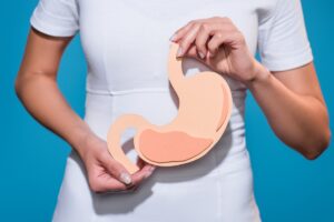 woman in white holding stomach
