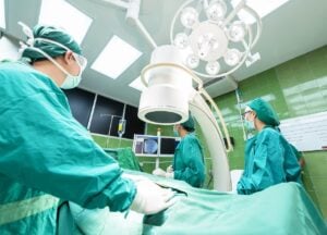 Surgeons performing a procedure, representing recovery after gastric bypass surgery in a sterile operating room.