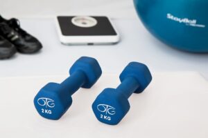 Dumbbells, scale, and exercise gear symbolize wegovy benefits for weight loss and fitness.