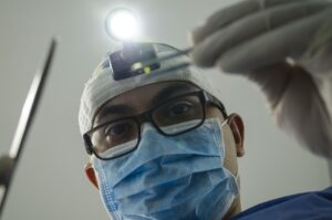 Surgeon in mask and headlamp working, illustrating bariatric surgery option over Ozempic.