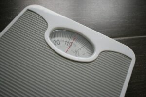 Weight Loss Plateaus. a bathroom scale sitting on top of a wooden table