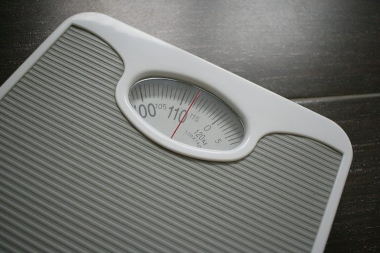 Weight Loss Plateaus. a bathroom scale sitting on top of a wooden table