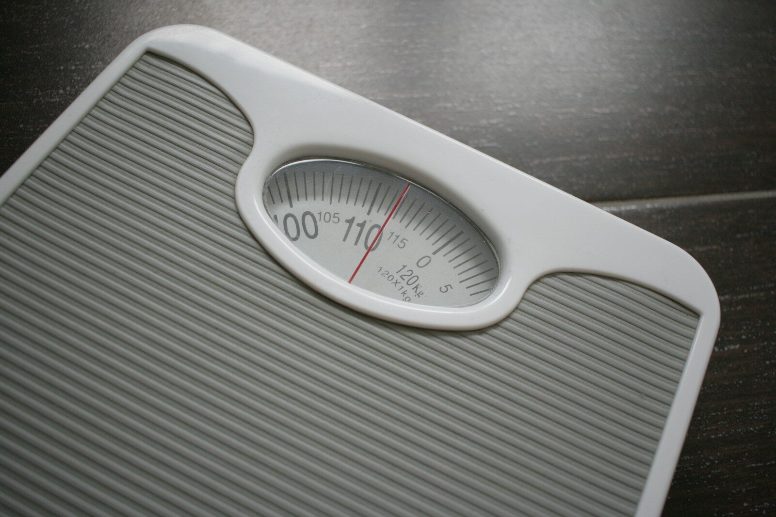 Weight Loss Plateaus. a bathroom scale sitting on top of a wooden table